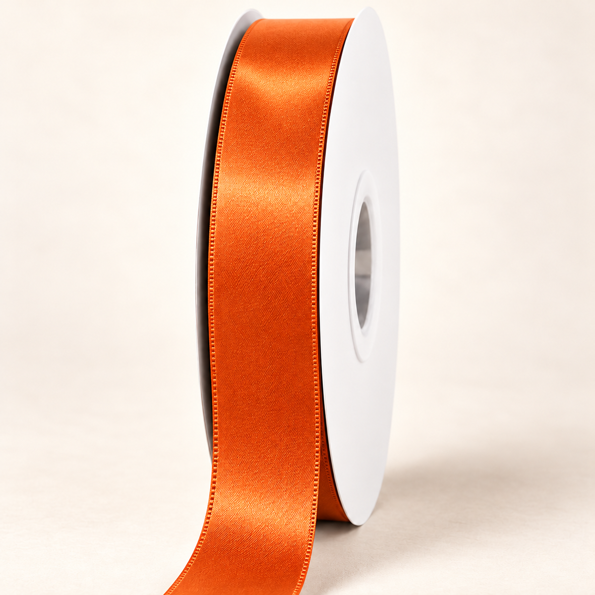 Autumn Orange — 22 mm satin ribbon on a white roll against an ivory background