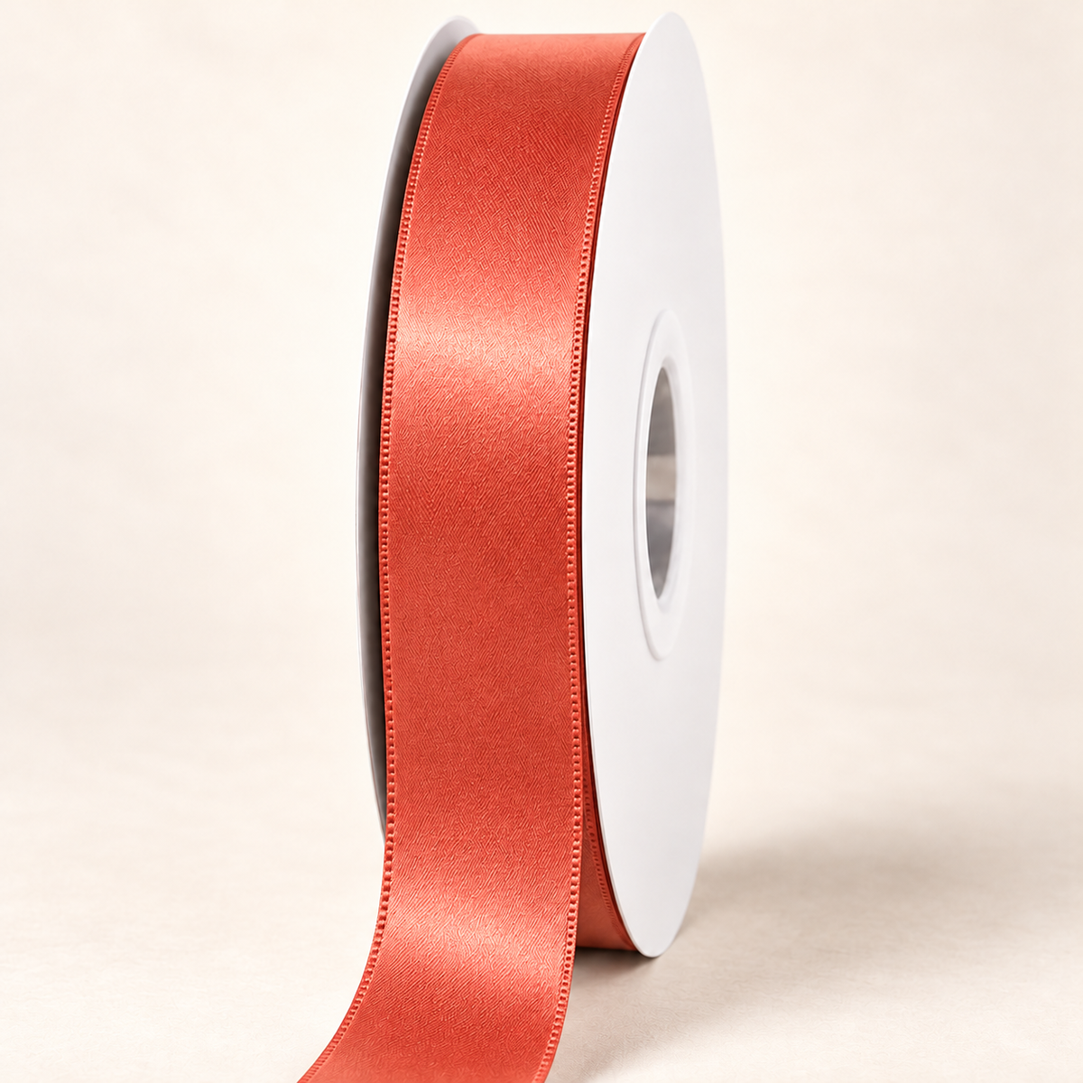 Mandarin Orange — 22 mm satin ribbon on a white roll against an ivory background