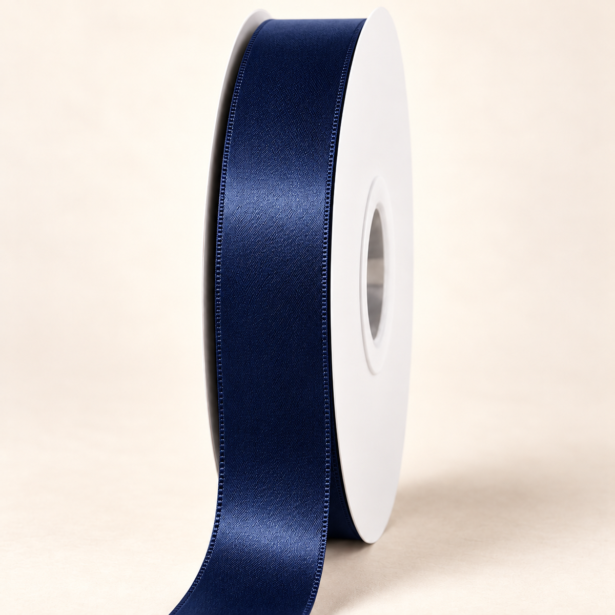 Navy — 22 mm satin ribbon on a white roll against an ivory background