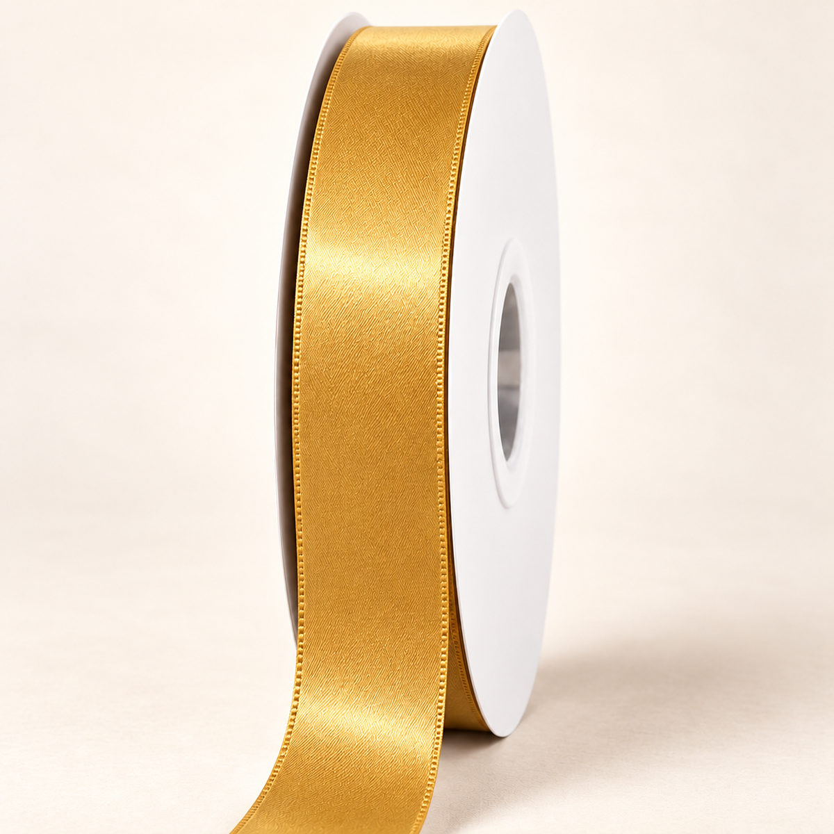 Old Gold — 22 mm satin ribbon on a white roll against an ivory background