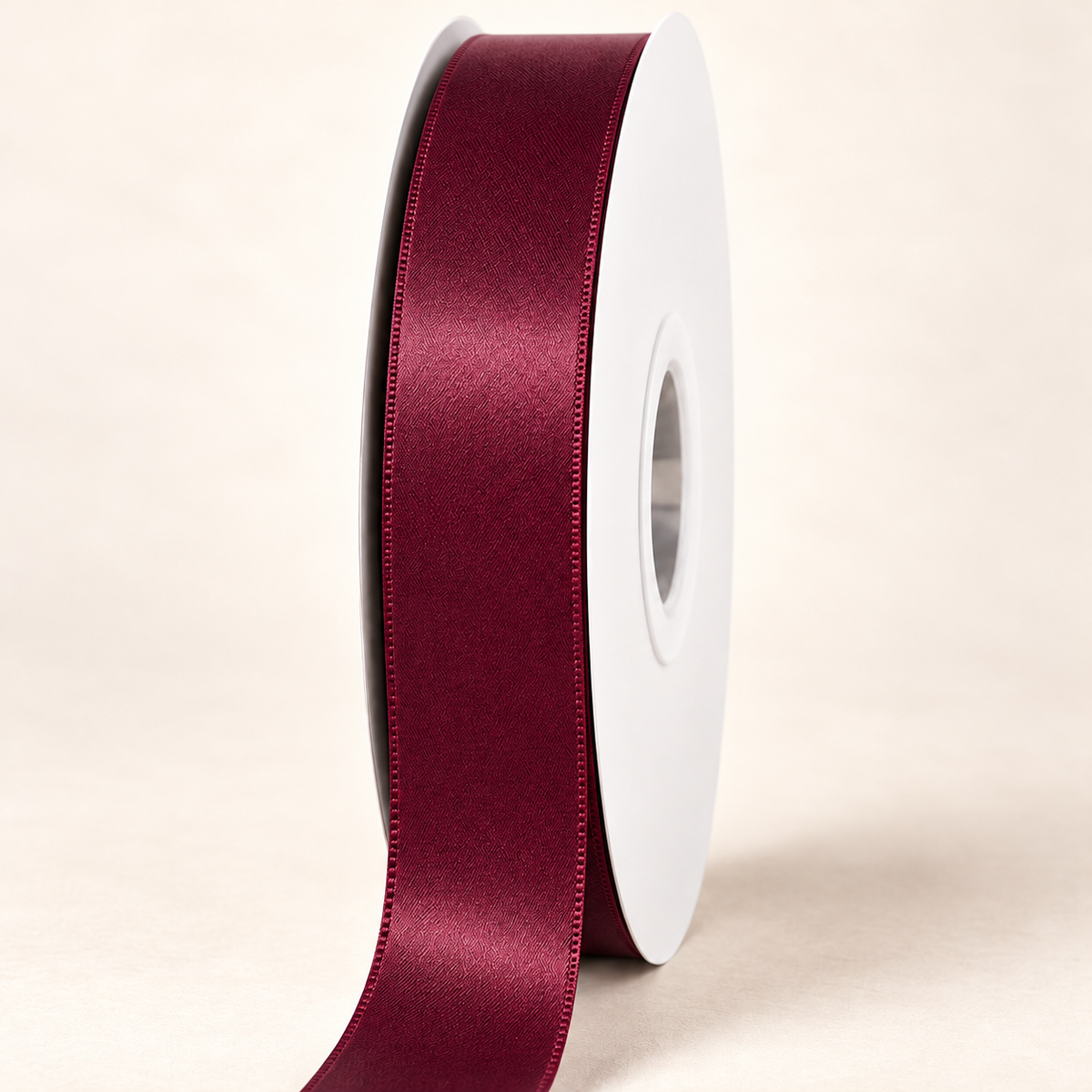 Wine — 22 mm satin ribbon on a white roll against an ivory background