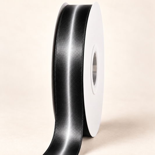 Basalt Double-Faced Satin Ribbon — 22 mm satin ribbon on a white roll against an ivory background
