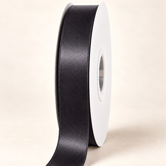Black — 22 mm satin ribbon on a white roll against an ivory background