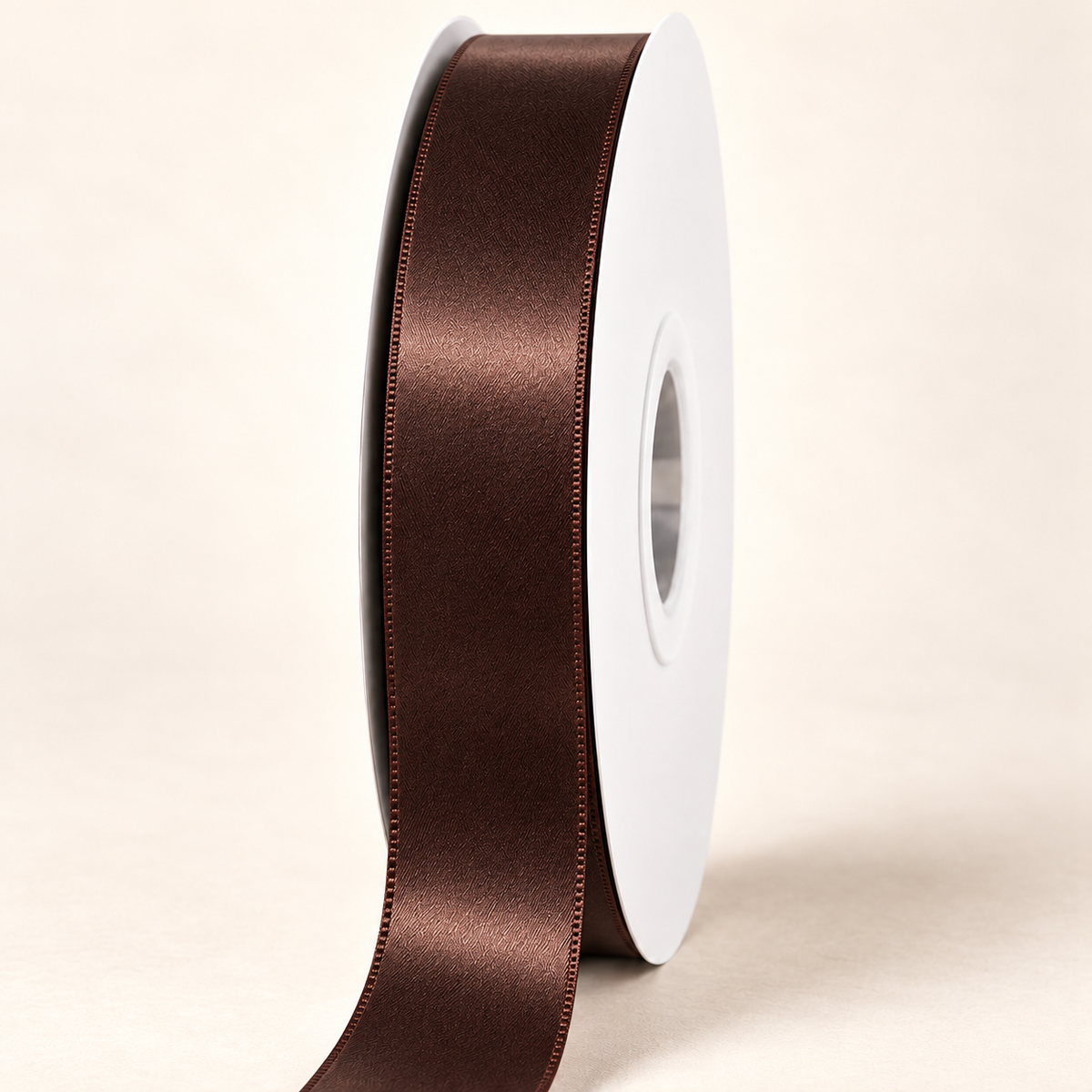 Black Coffee — 22 mm satin ribbon on a white roll against an ivory background