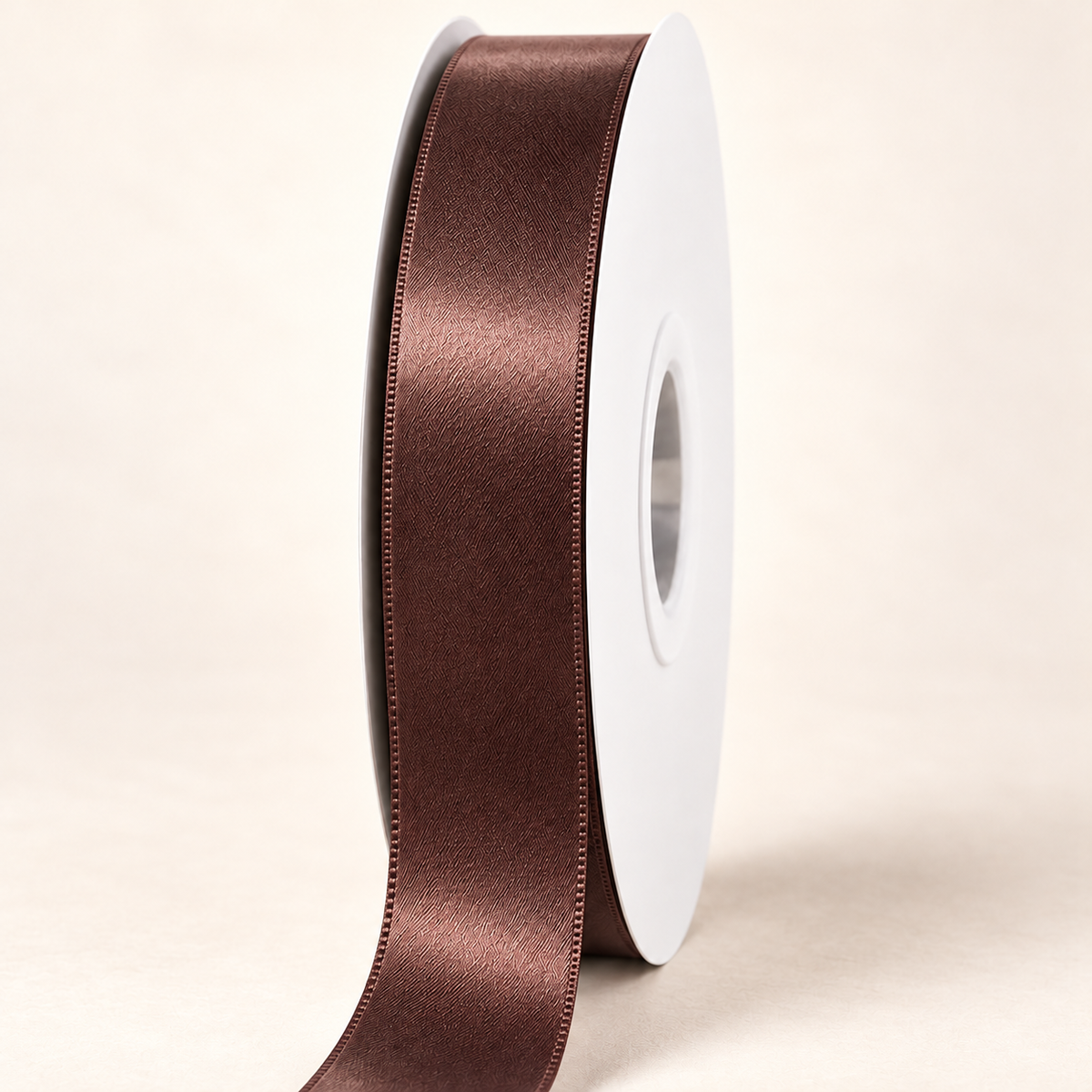 Brown — 22 mm satin ribbon on a white roll against an ivory background