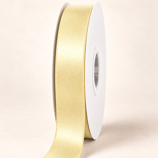 Buttercup — 22 mm satin ribbon on a white roll against an ivory background