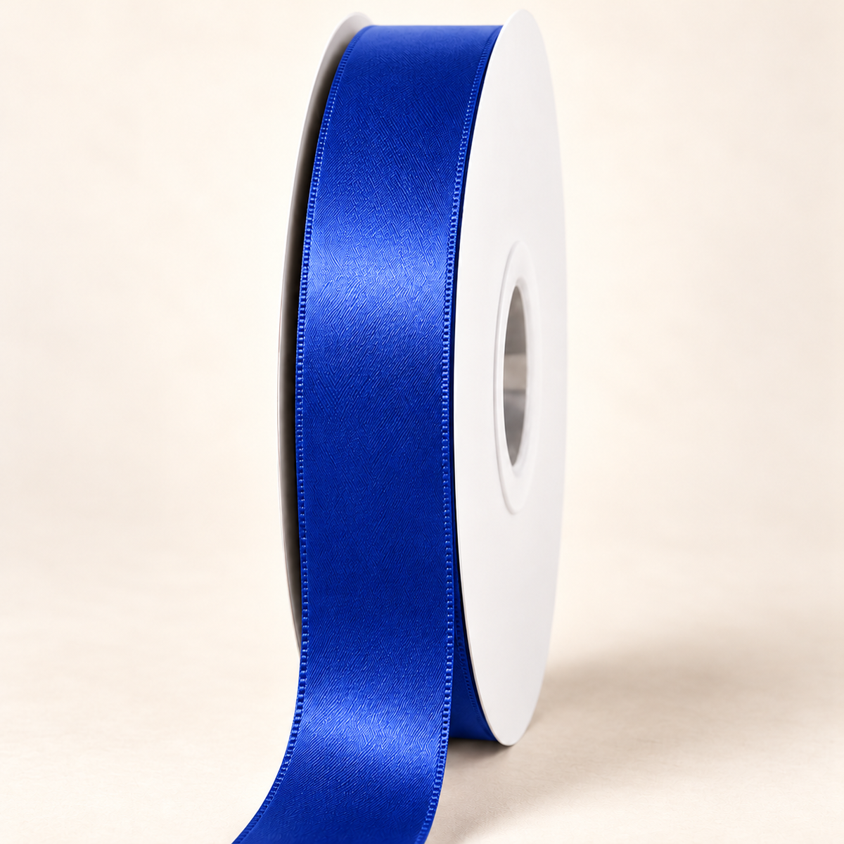 Cobalt — 22 mm satin ribbon on a white roll against an ivory background