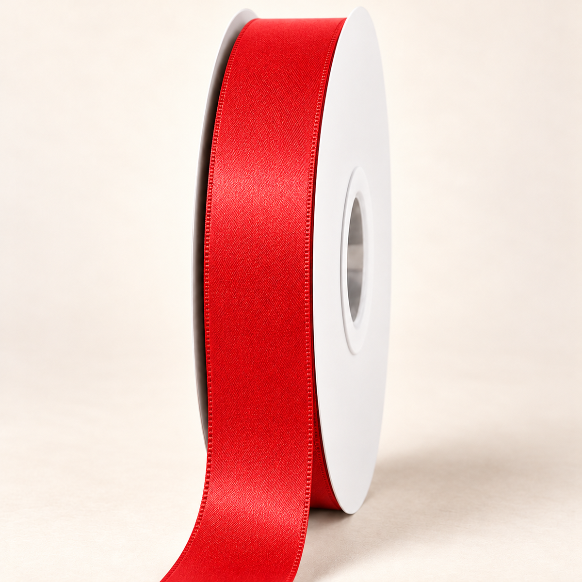 Hot Red — 22 mm satin ribbon on a white roll against an ivory background
