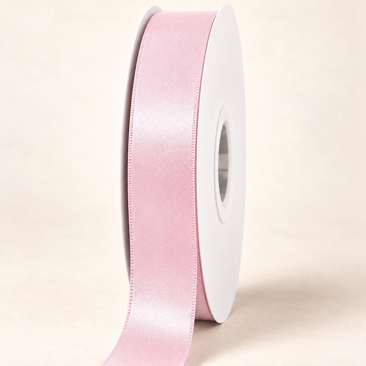 Icy Pink — 22 mm satin ribbon on a white roll against an ivory background
