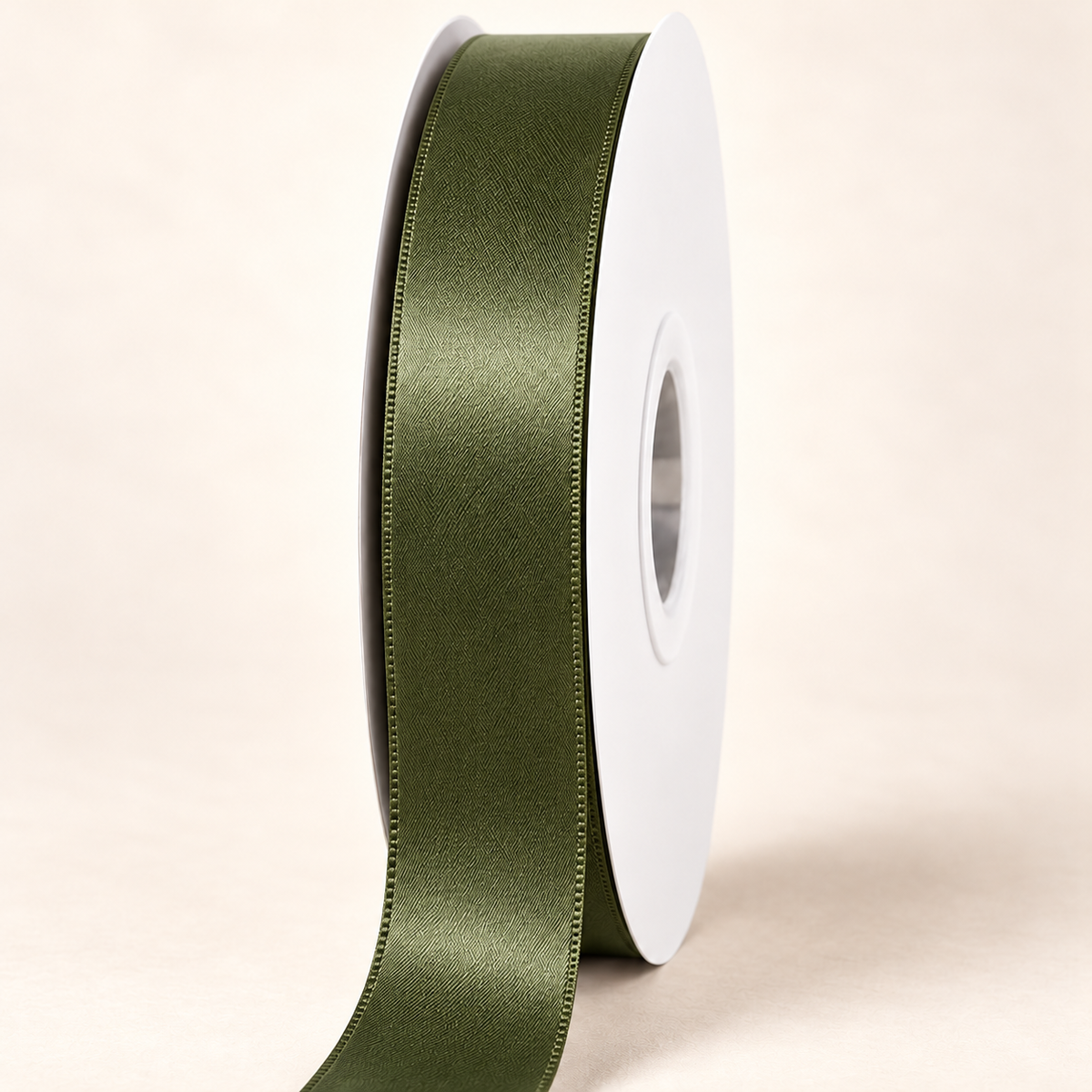 Moss — 22 mm satin ribbon on a white roll against an ivory background