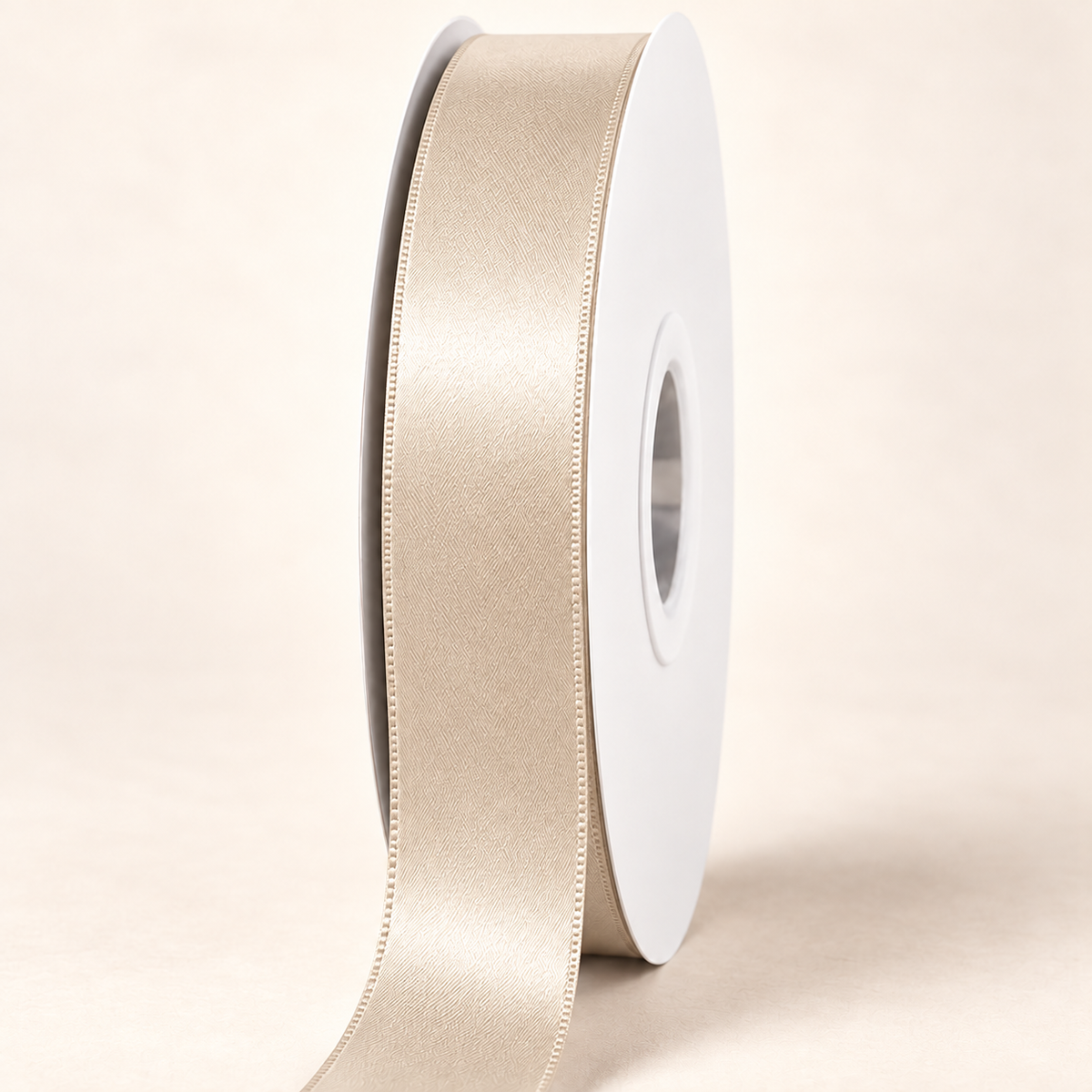 Nude — 22 mm satin ribbon on a white roll against an ivory background