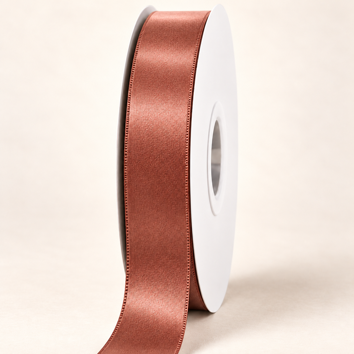 Pecan Brown — 22 mm satin ribbon on a white roll against an ivory background
