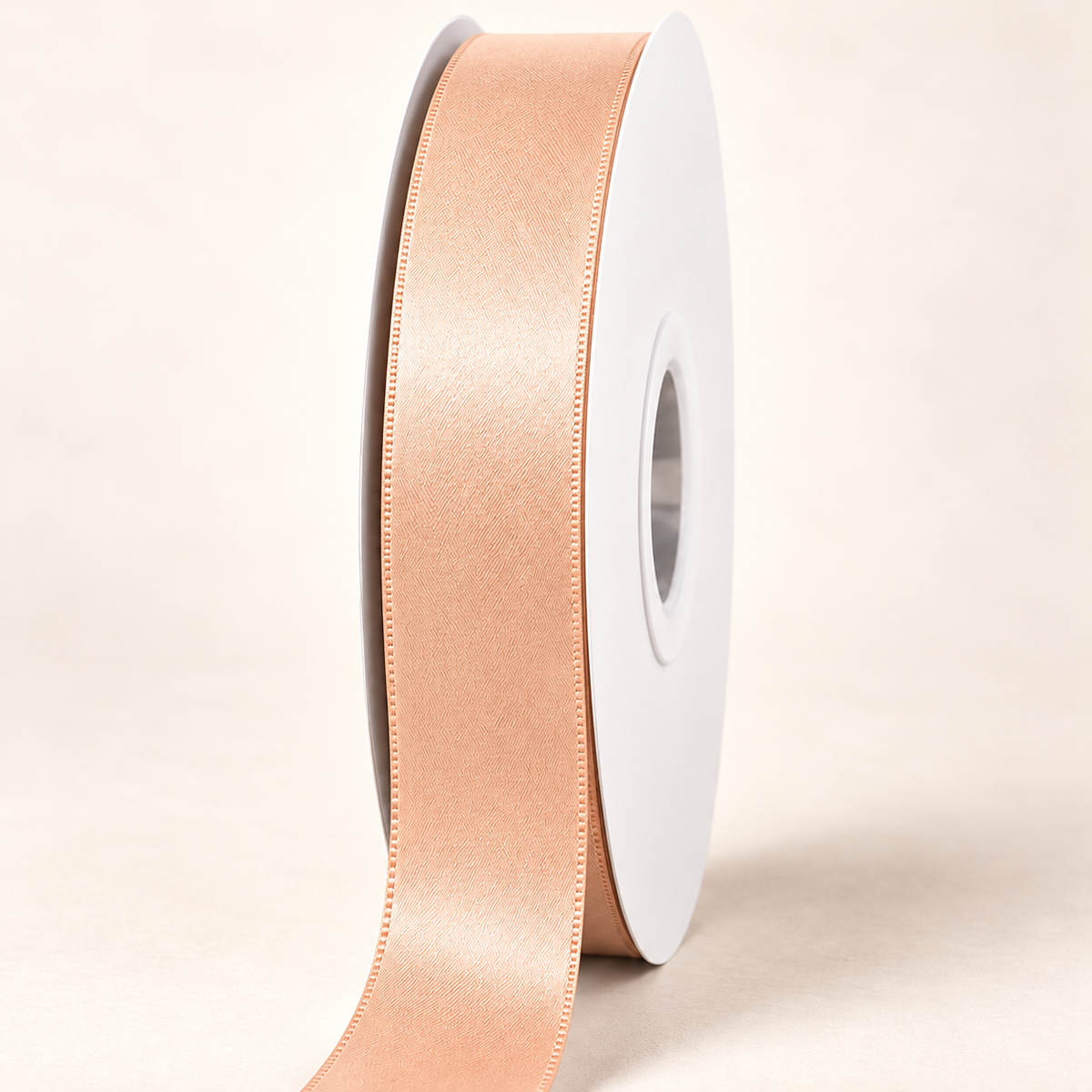 Petal Peach — 22 mm satin ribbon on a white roll against an ivory background