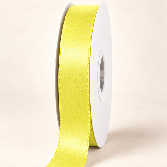 Pistachio — 22 mm satin ribbon on a white roll against an ivory background