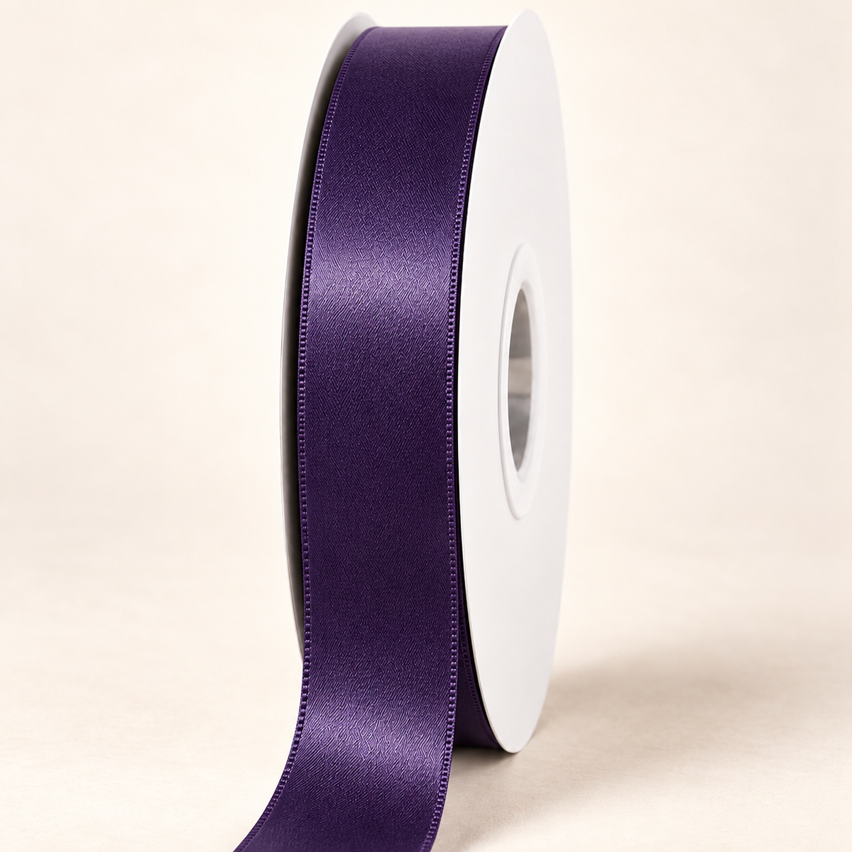 Plum — 22 mm satin ribbon on a white roll against an ivory background