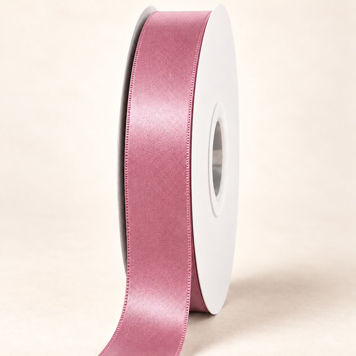 Rosy Mauve — 22 mm satin ribbon on a white roll against an ivory background