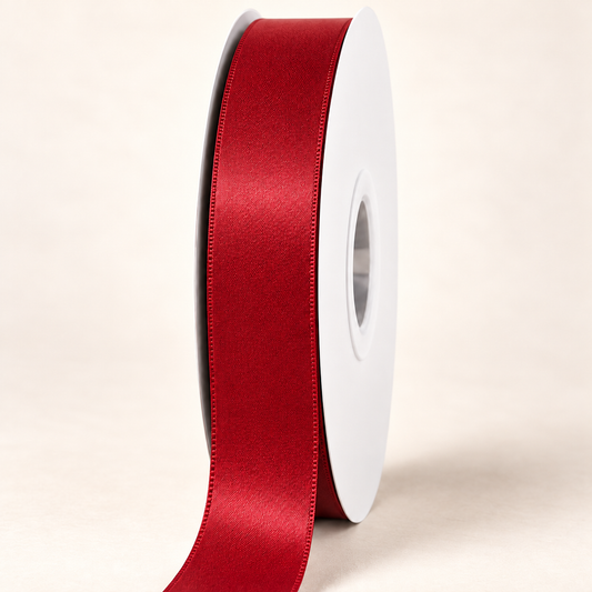 Ruby — 22 mm satin ribbon on a white roll against an ivory background